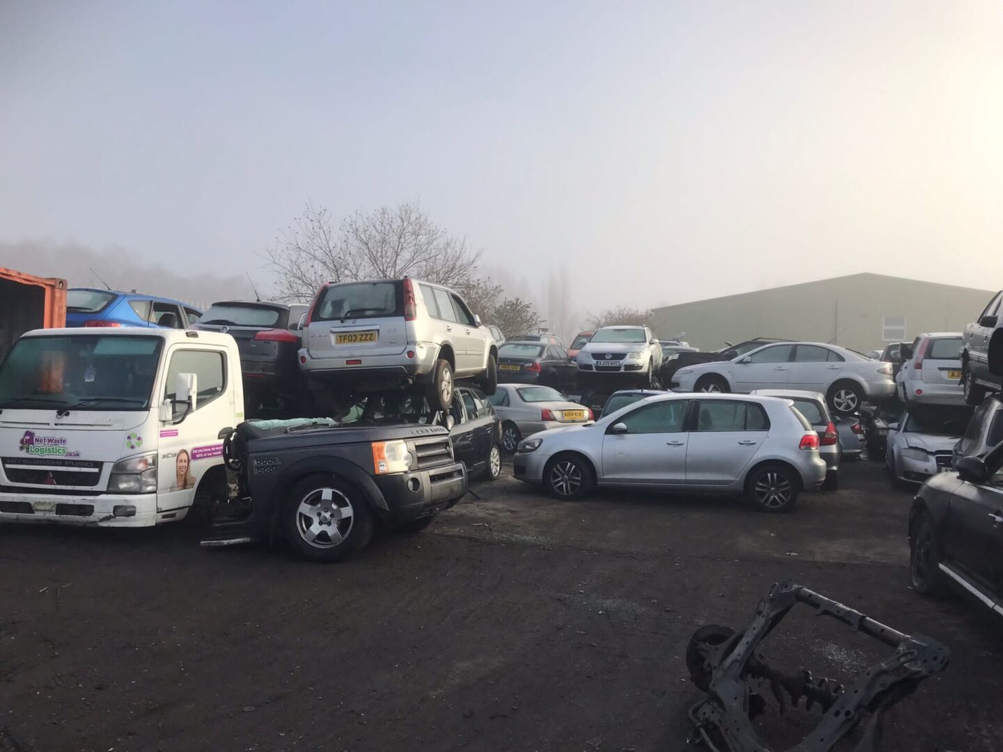 A group of cars parked in the dirt.