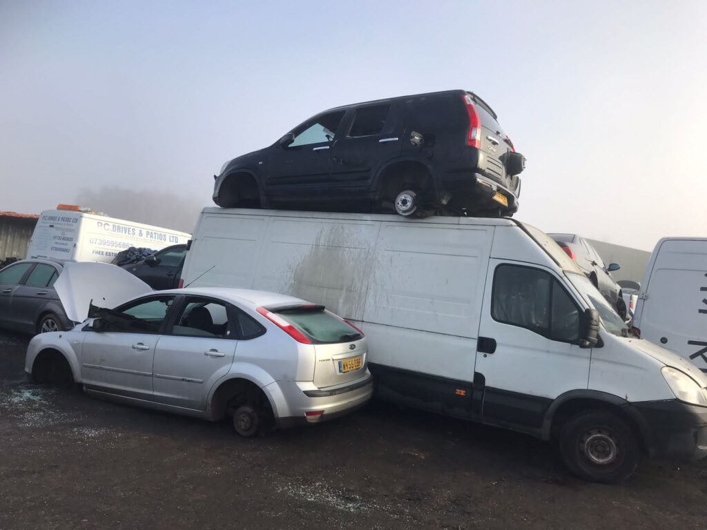 A van with two cars on top of it.