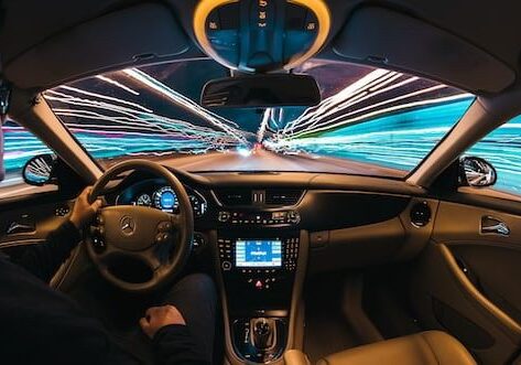 A car driving down the street at night.